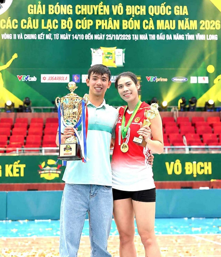 Kình ngư Nguyễn Huy Hoàng chụp ảnh cùng bạn gái Lâm Oanh, sau khi đội bóng chuyền Binh Chủng Thông Tin vô địch quốc gia 2026, tại nhà thi đấu Vĩnh Long tối 25/10. Ảnh: FBNV