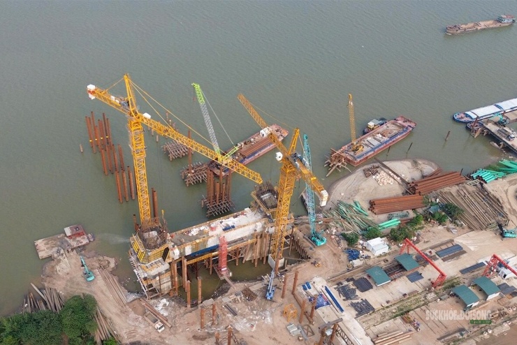 Trụ cầu bê tông dần thành hình giữa hệ giàn giáo, cốt thép và máy móc thi công. Ảnh: Tuấn Anh