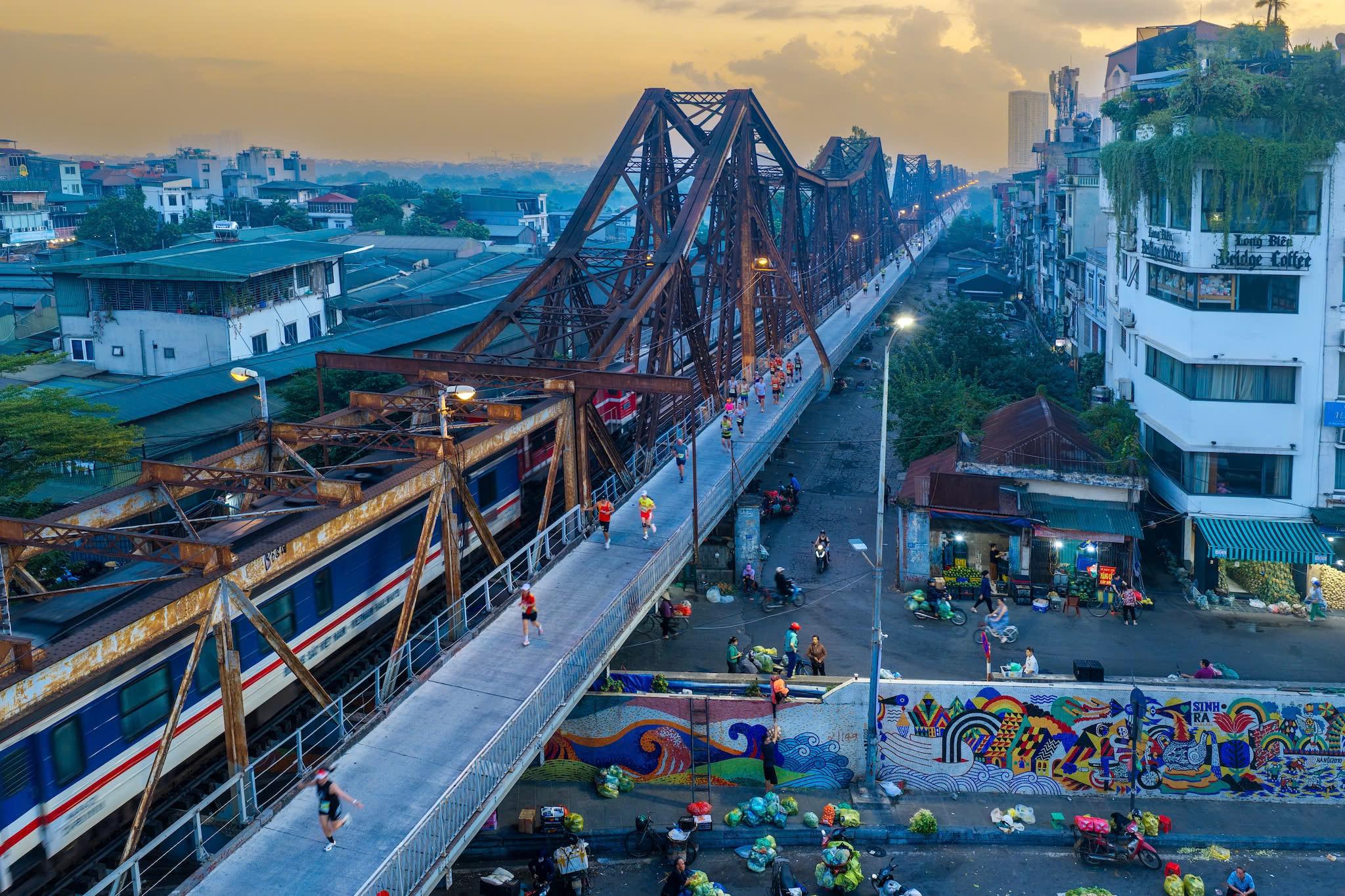 Cầu Long Biên trong ánh bình minh, chứng kiến những bước chạy bền bỉ của các vận động viên VPIM 2026.